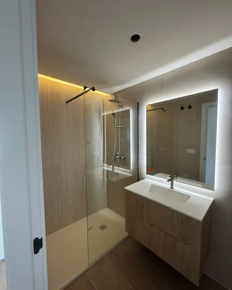 Ducha con revestimiento efecto madera y espejo con luz LED